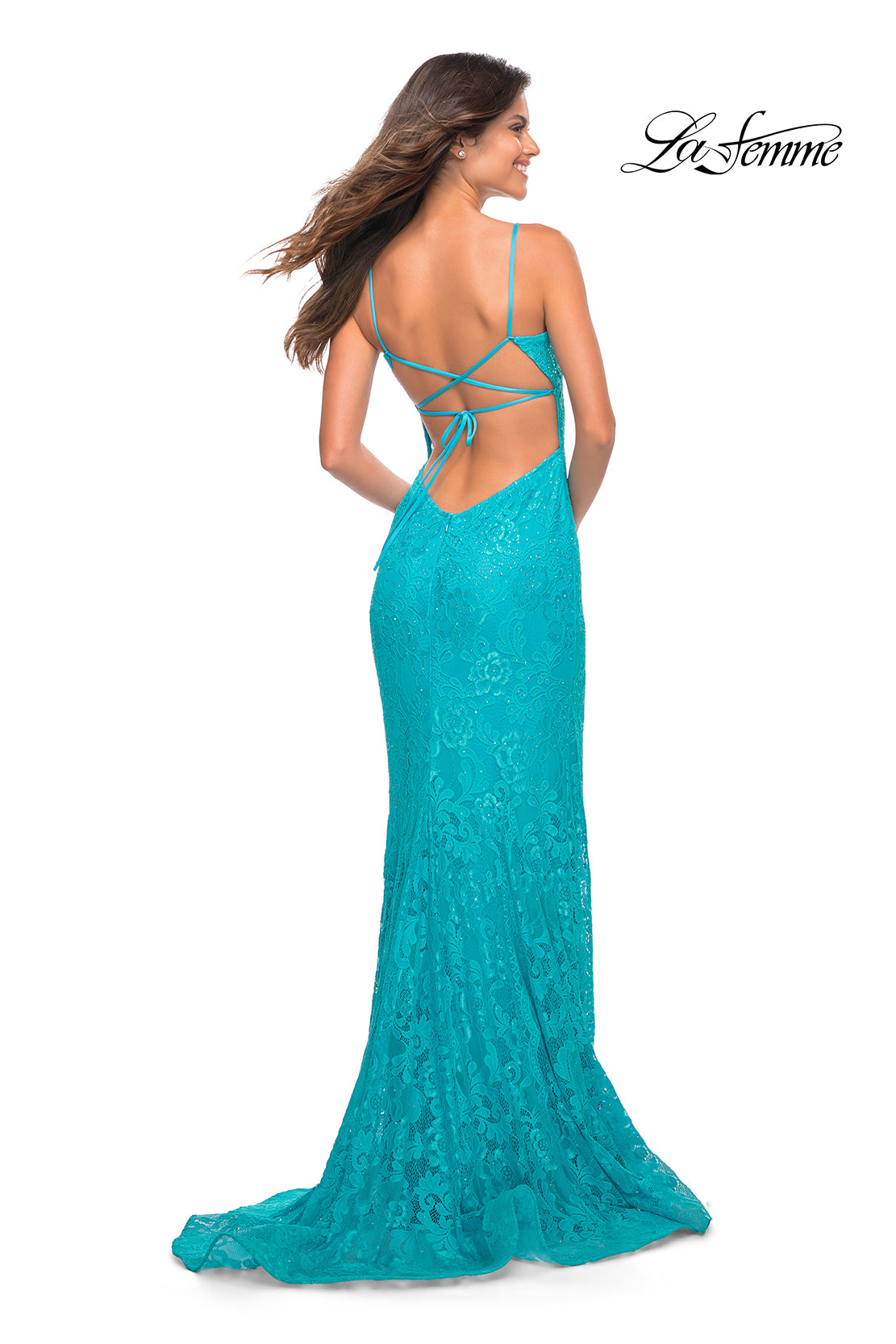 Woman in a La Femme Stretch Lace Long Strappy-Back Prom Dress in turquoise, featuring an open back with crisscross straps, standing and facing away from the camera.